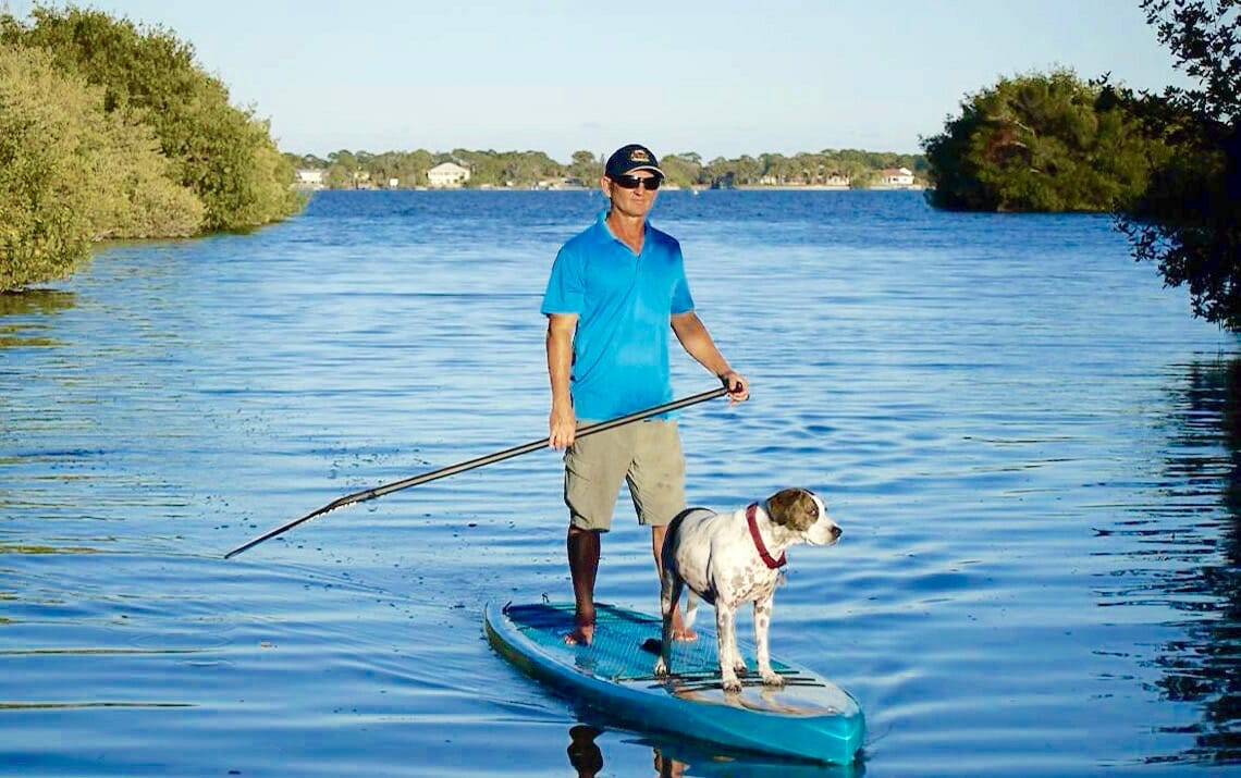 Girard Middleton of SoBe Surf on a Riviera Paddlesurf Voyager Classic 12’6″ with dog Kona Girard Middleton of SoBe Surf on a Riviera Paddlesurf Voyager Classic SUP Stand up Touring Board 12'6" dog Kona